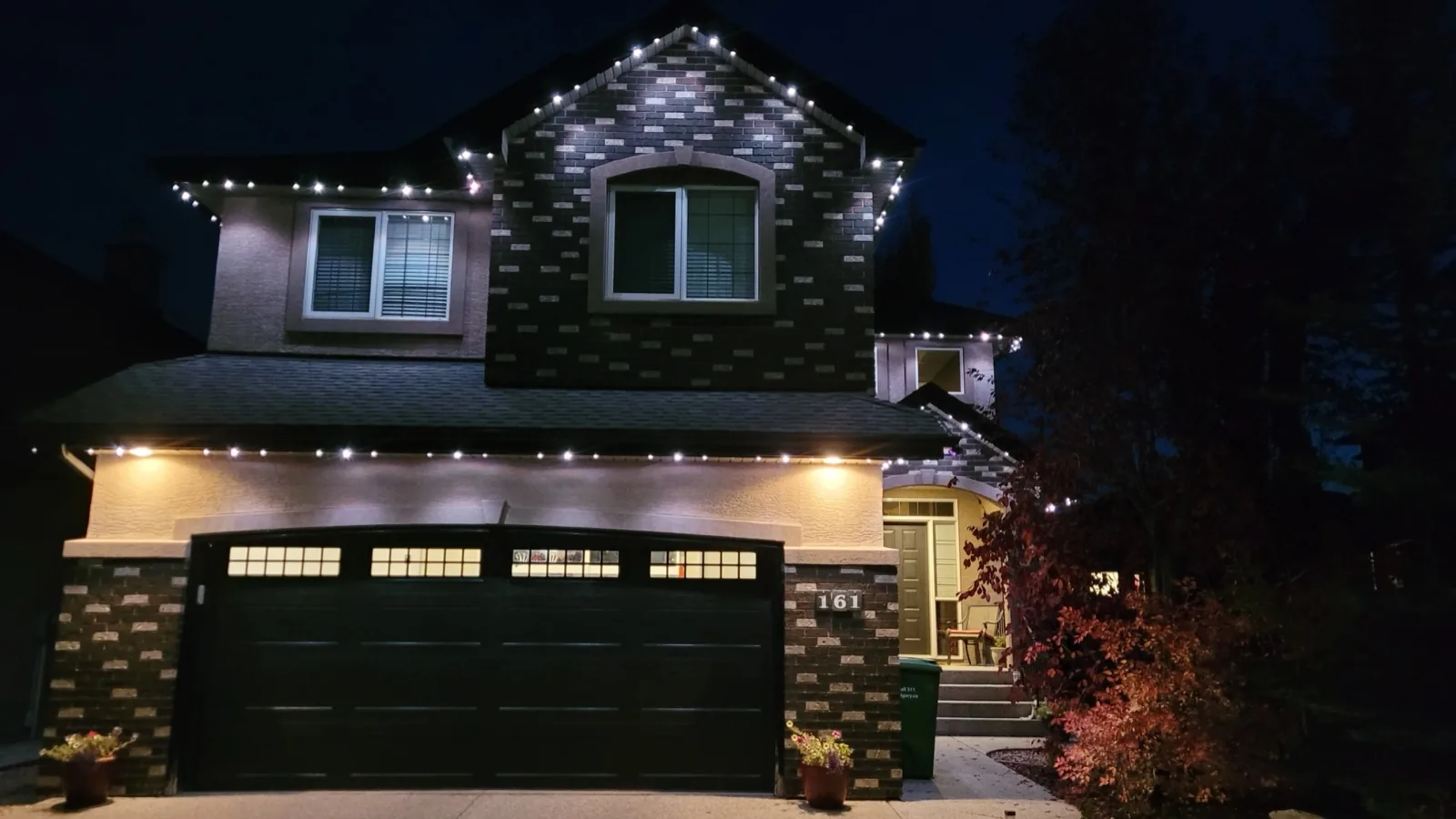 Two-storey Calgary home at dusk outlined in warm white Diamond Bright permanent LED trim lighting